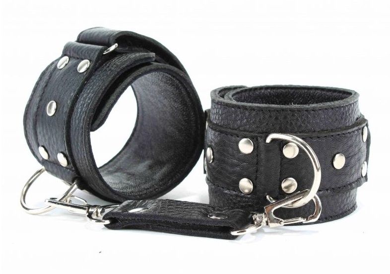 Кожаные наручники черного цвета. Украшены заклепками и соединяются между собой цепью с карабинами. Размер наручников регулируется при помощи застежки-липучки. Подойдут на обхват руки от 15 до 20 см. Ширина - 5 см.<br> Длина цепочки - 14 см.