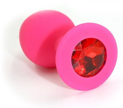 Анальная пробка из силикона розового цвета, размер M. Страз в основании круглой формы,  выполнен из стекла красного цвета. Упакована в вельветовый мешочек для хранения. Вес - 46,5 граммов.