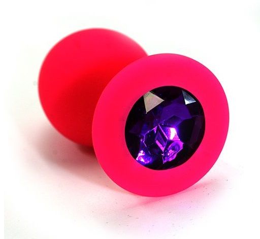 Анальная пробка из силикона розового цвета, размер M. Страз в основании круглой формы,  выполнен из стекла темно-фиолетового цвета. Упакована в вельветовый мешочек для хранения. Вес - 46,5 граммов.