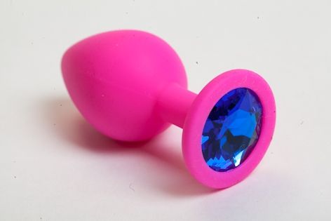 Розовая анальная пробка с синим кристаллом. Широкое основание позволяет максимально безопасно использовать этот интимный аксессуар.