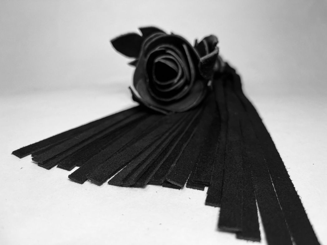 Восхитительная мини-плеть, украшенная чёрной розой. Цветок полностью выполнен из натуральной лаковой кожи, листочки розы и рукоятка выполнены из мягкой натуральной кожи, а хвосты плети - натуральная мягкая замша. Размеры этой плети очень изящны, поэтому данную плеть можно использовать, как генитальную, чтобы добавить новых ярких ощущений. Розочка очень удобно лежит в руке и создает неповторимую атмосферу и настроение, этот аксессуар никого не оставит равнодушным!