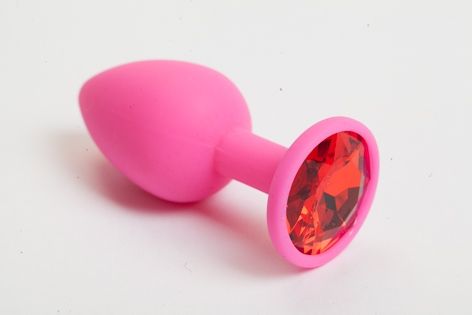 Розовая анальная пробка с красным кристаллом. Широкое основание позволяет максимально безопасно использовать этот интимный аксессуар.