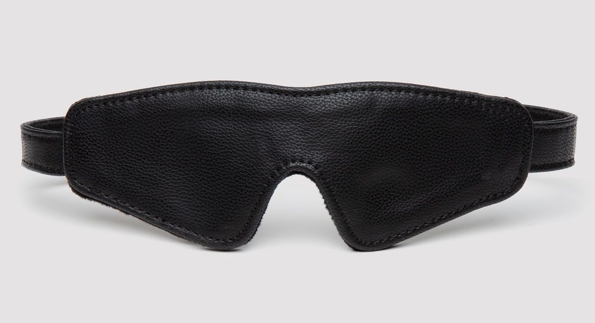 Черная плотная маска на глаза Bound to You Faux Leather Blindfold. Застежка регулируется при помощи пряжки (не содержит никель).