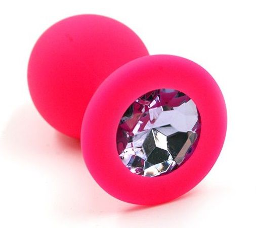 Анальная пробка из силикона розового цвета, размер M. Страз в основании круглой формы,  выполнен из стекла светло-розового цвета. Упакована в вельветовый мешочек для хранения. Вес - 46,5 граммов.