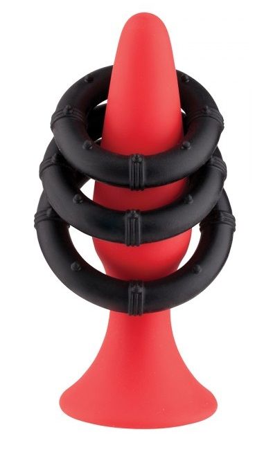 Красный плаг для анальной стимуляции из силикона.  В наборе 3 черных силиконовых кольца, которые можно использовать на пенисе и мошонке.  Диаметр колец - 3, 3,5 и 4 см.<br> Рабочая длина пробки - 10 см., диаметр - 3 см.
