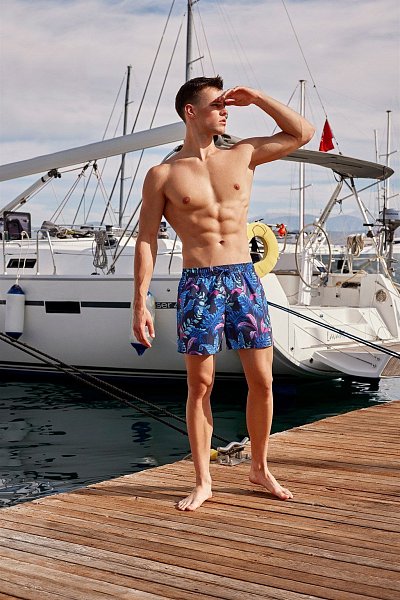 Мужские пляжные шорты от Doreanse тёмно-синего цвета с ярким тропическим принтом. Очень мягкий и приятный для тела материал. Внутри вшита эластичная поддерживающая сеточка. По бокам 2 удобных вшивных кармана, сзади 1 карман с застёжкой-молнией. В эластичный пояс вставлен регулирующий шнурок с логотипом «Doreanse» и стильными металлическими наконечниками.