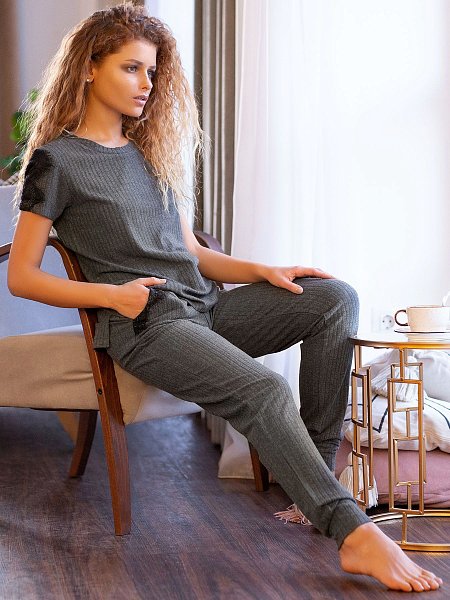 Женский комплект: футболка с коротким рукавом и брюки из мягкого трикотажа «в рубчик» на основе вискозы. Лаконичный, чуть расклешенный силуэт, приятная струящаяся ткань на основе вискозы, спокойный и благородный серый цвет, сдержанный декор в виде кружевных лампасов на рукавах. В комплекте: футболка, брюки.